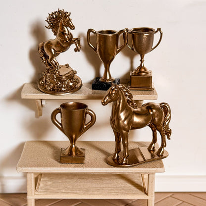 Gold horse trophy set: a rearing horse statue, a standing horse statue and three trophy cups on a miniature shelf and table for Schleich model horses