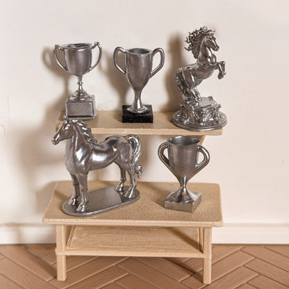 Silver horse trophy set: a rearing horse statue, a standing horse statue and three trophy cups on miniature shelves for Schleich model horses
