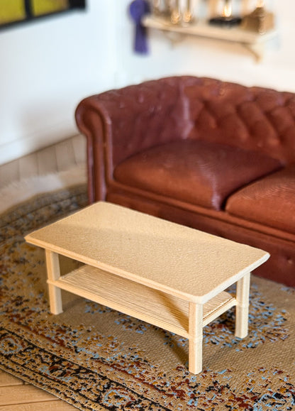Miniature light oak coffee table with a lower shelf in front of a brown tufted couch, for a Schleich model horse clubhouse