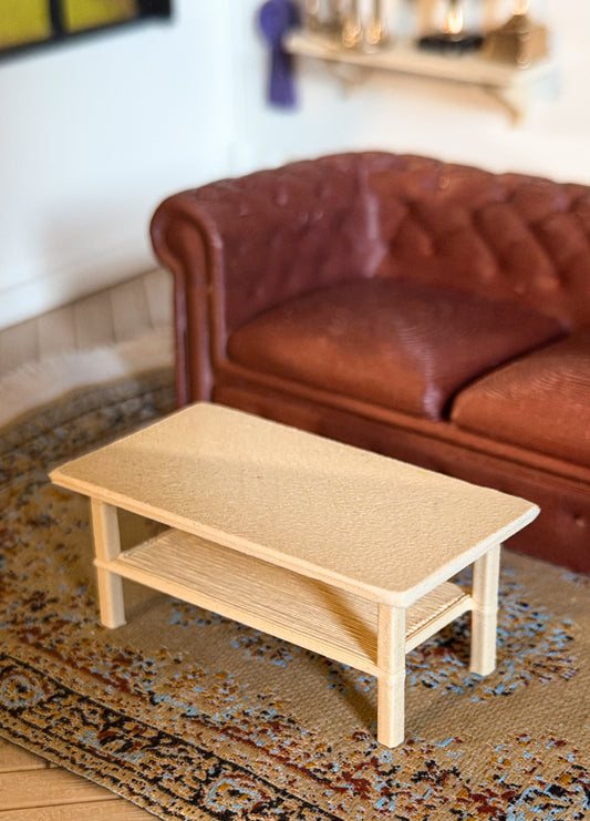 Miniature light oak coffee table with a lower shelf in front of a brown tufted couch, for a Schleich model horse clubhouse