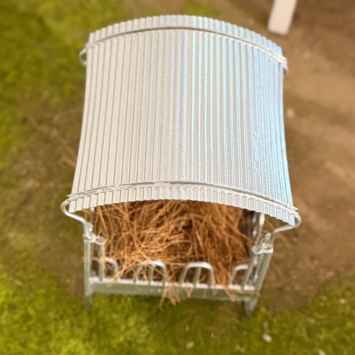 Top-down view of the covered hay rack's curved corrugated metal canopy roof